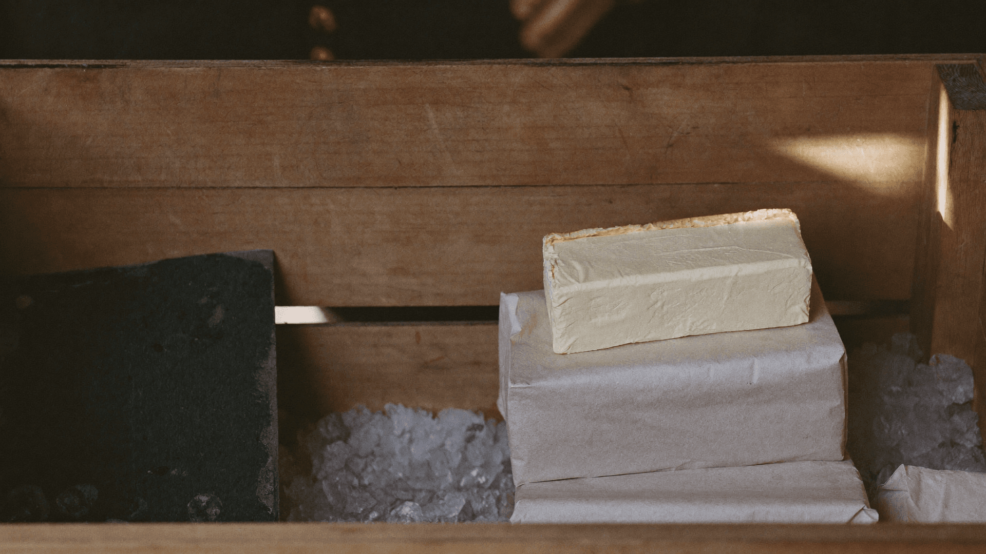 Panetti e confezioni di burro disposti ordinatamente su un banco frigo luminoso di un supermercato svizzero, confrontati per tipo e valore