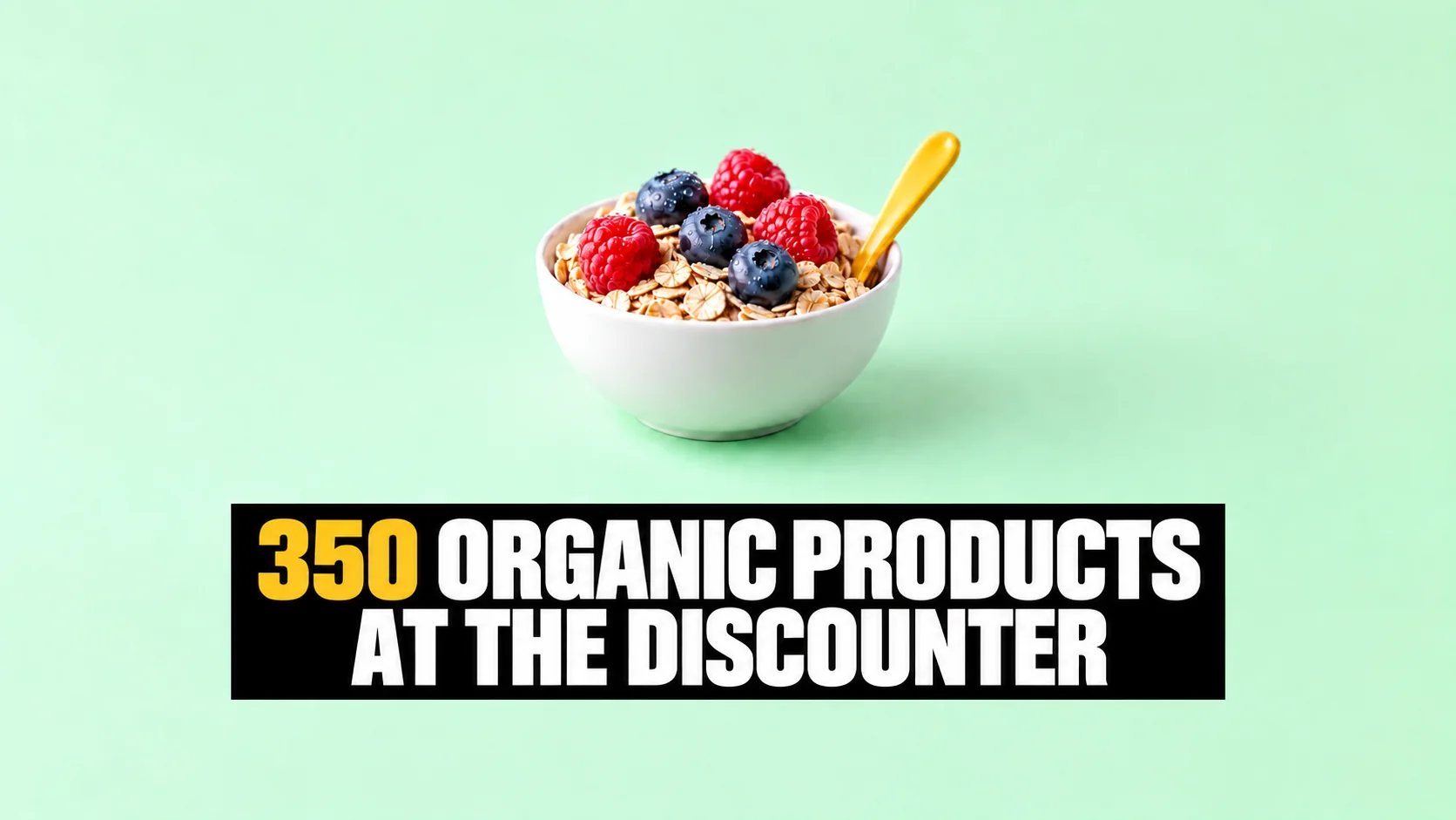 Macro photograph of a white bowl of oats and berries with a yellow spoon on a mint-green background.