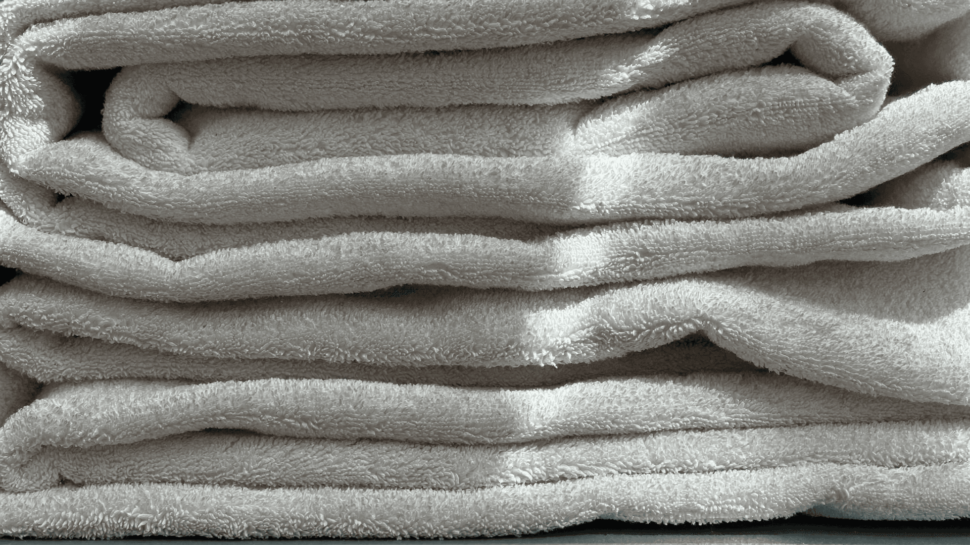 Paquets de lessive côte à côte dans un rayon suisse, avec le nombre de lavages indiqué sur l'emballage